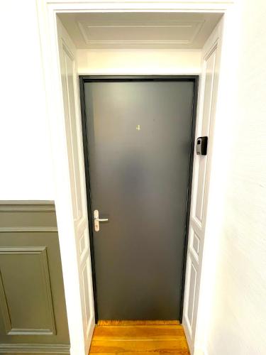 a hallway with a gray door in a room at Résidence Adam à part in Valenciennes