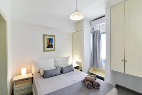 una camera con un letto bianco con due cuscini di Thomas Apartments in Katapola ad Amorgo