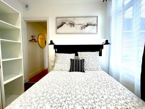a bedroom with a bed with a black and white bedspread at Résidence Adam à part in Valenciennes