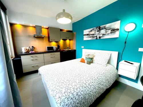 a bedroom with a white bed and a blue wall at Résidence Adam à part in Valenciennes
