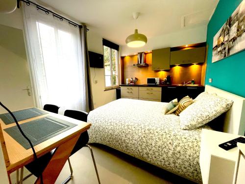 a bedroom with a bed and a desk with a laptop at Résidence Adam à part in Valenciennes
