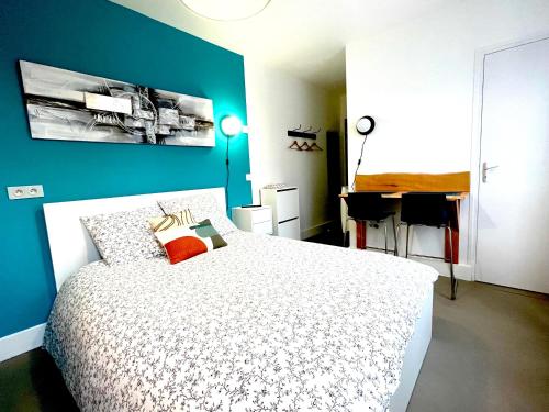a bedroom with a white bed and a blue wall at Résidence Adam à part in Valenciennes