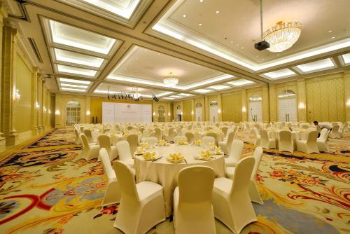 a large banquet hall with white tables and white chairs at Orient-Anyi international Hotel in Beijing