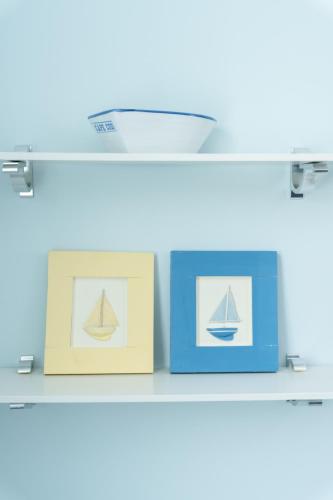 two boxes on a shelf with a picture of a sailboat at Candleberry Inn on Cape Cod in Brewster