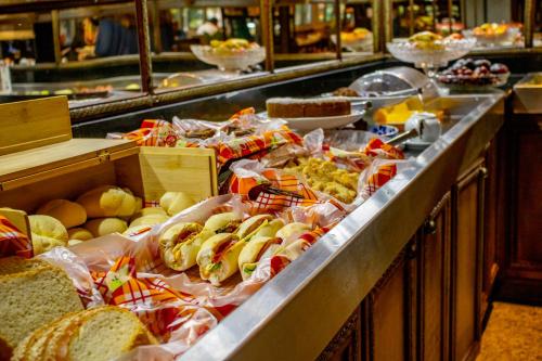 a counter filled with lots of different types of food at Manhattan Porto Alegre by Mercure in Porto Alegre