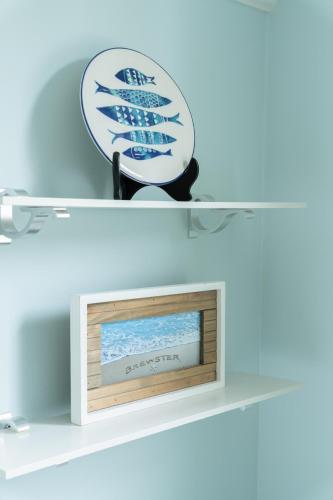 a picture frame on a shelf with a clock on it at Candleberry Inn on Cape Cod in Brewster