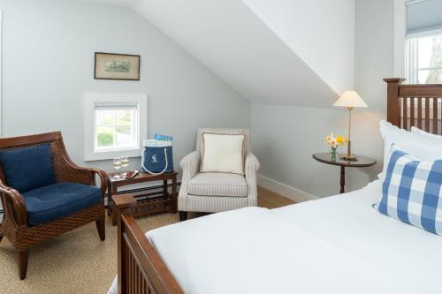 a bedroom with a bed and a chair and a desk at Candleberry Inn on Cape Cod in Brewster