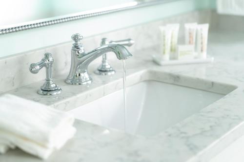 a bathroom sink with water running from two faucets at Candleberry Inn on Cape Cod in Brewster