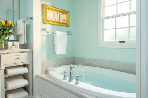 a bathroom with a tub and a window at Candleberry Inn on Cape Cod in Brewster