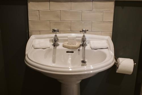 a white sink in a bathroom with toilet paper at Galgorm in Ballymena