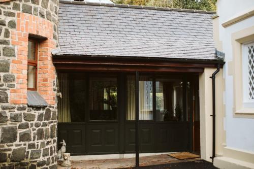 a garage with a black door and a brick building at Galgorm in Ballymena