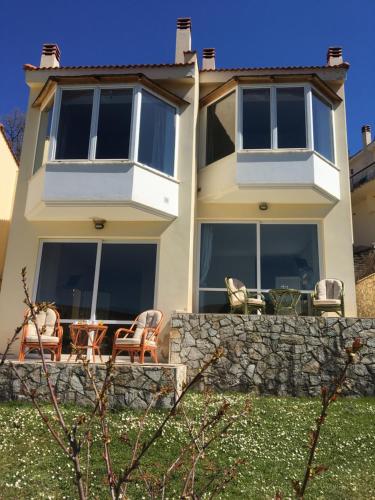 a house with chairs and a stone wall at Anarada Guesthouse in Synikia Mesi Trikalon