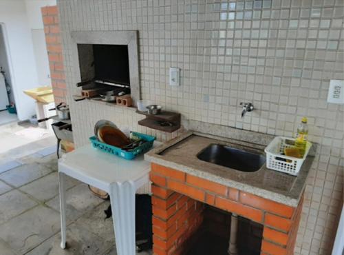 cocina con fregadero y pared de ladrillo en Pousada BarraVille en Barra Velha