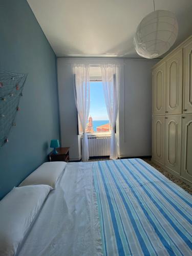 Un dormitorio con una cama grande y una ventana en Amazing Apartment, en Tellaro