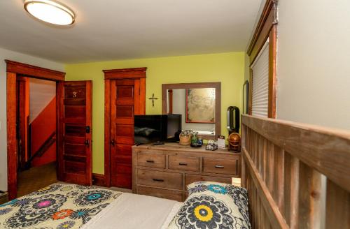 a bedroom with a bed and a dresser and a television at Berrodin Bed & Breakfast in Akron