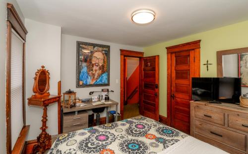 a bedroom with a bed and a desk and a television at Berrodin Bed & Breakfast in Akron
