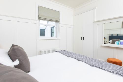 a white bedroom with a bed and a window at Galgorm in Ballymena
