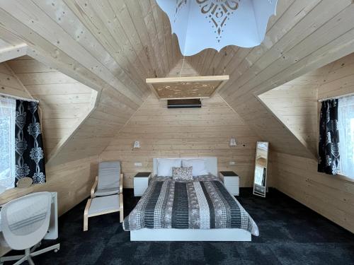 a bedroom with a bed and chairs in a room at Stachelisko - domki i pokoje in Chochołów