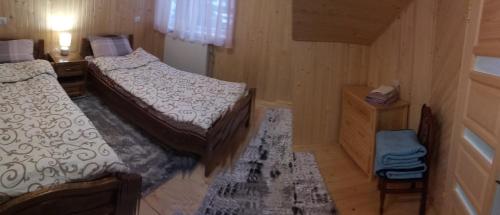a small bedroom with two beds and a dresser at Sova in Lazeshchyna