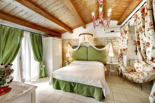 1 dormitorio con cama y lámpara de araña en Villa U Marchisi B&B, en Scicli