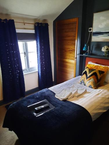 a bedroom with a bed with a remote control on it at The Coach and Horses Inn in Chepstow
