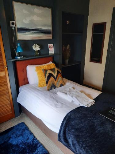 a bedroom with a bed with white sheets and pillows at The Coach and Horses Inn in Chepstow