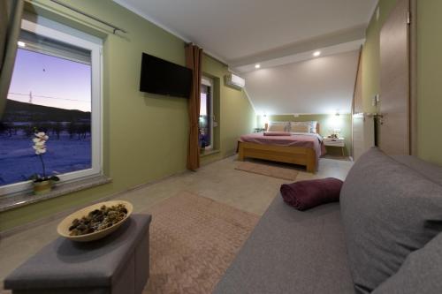 a bedroom with a bed and a couch and a window at Kuća za odmor 'Teuta' in Vrhovine