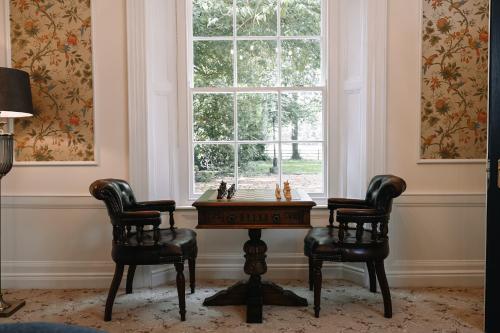a room with a table and two chairs and a window at Galgorm in Ballymena