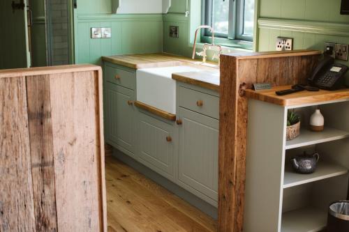 a kitchen with green cabinets and a sink at Galgorm in Ballymena
