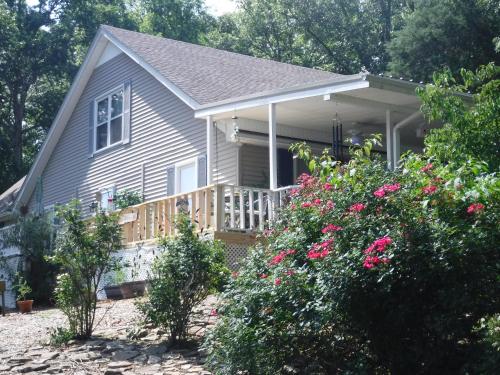 a house with a porch and a deck with flowers at Serenityhill bed and breakfast in Brownsville