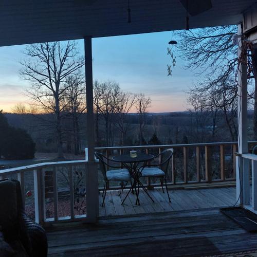 a porch with a table and chairs on a deck at Serenityhill bed and breakfast in Brownsville