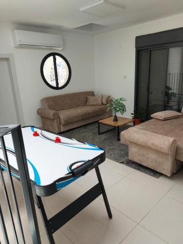 a living room with a table and a couch at וילה שחר בגולן in Mas'ade