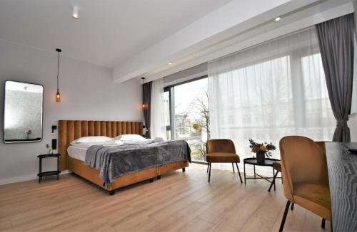 a bedroom with a bed and a large window at Patio Riverfront Aparthotel in Gdańsk