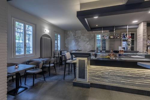 a restaurant with a bar and some tables and chairs at Villa Petra in Novellara