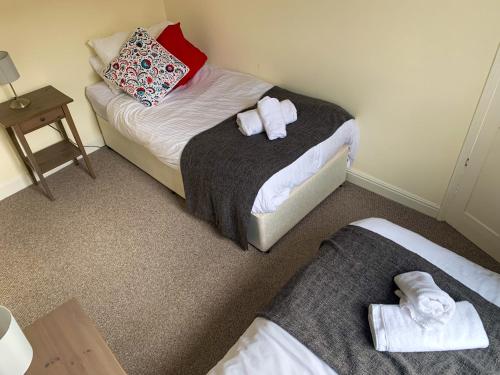 two beds in a room with towels on them at Park Crescent Lodge - Quaint Victorian Home With Free Parking in York