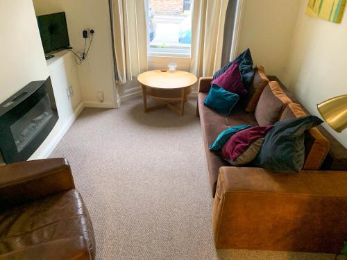 a living room with a couch and a table at Park Crescent Lodge - Quaint Victorian Home With Free Parking in York