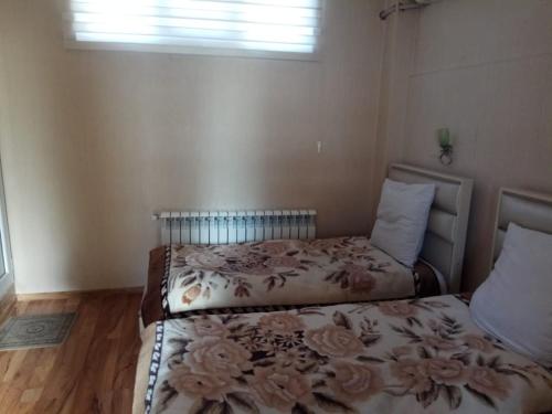 a bedroom with two beds and a window at Sheki Guest House in Sheki