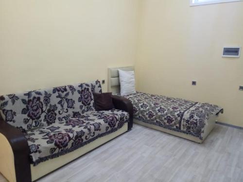 a couch and a bed in a room at Sheki Guest House in Sheki