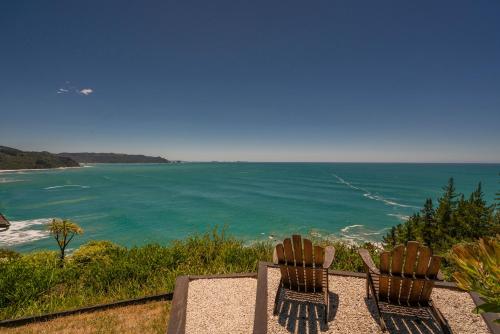 two chairs sitting on top of a overlook of the ocean at Oceana Heights Paradise - Beautiful 2 bdrm self contained apartment in Tairua