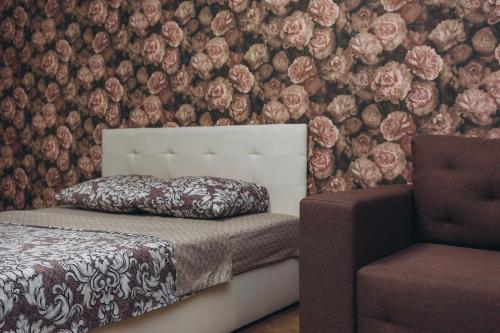 a bedroom with a bed and a chair and flowers at Apart-smart 5.26 near Lavina 8 floor Kharkovskaya in Sumy