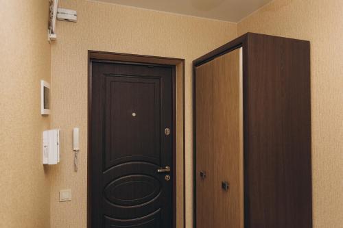 a black door in a hallway next to a room at Apart-smart 5.26 near Lavina 8 floor Kharkovskaya in Sumy