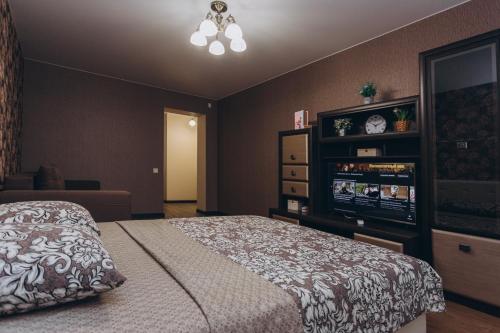 a bedroom with a bed and a dresser at Apart-smart 5.26 near Lavina 8 floor Kharkovskaya in Sumy