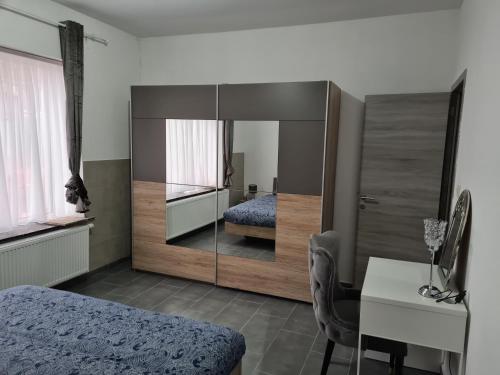 1 dormitorio con cama, escritorio y espejo en Harmonie 2 chambres parking et wifi gratuits en Charleroi