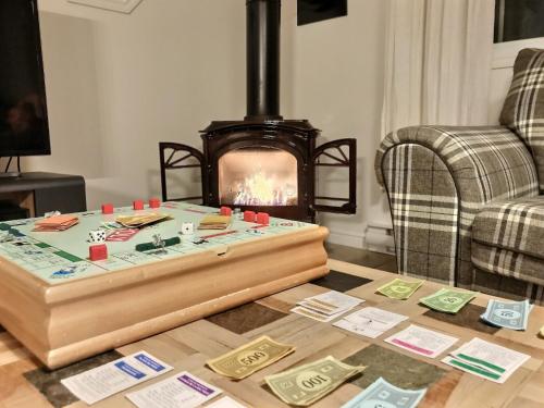 a living room with a table and a fireplace at Le Relais de la Martine in Petite-Rivière-Saint-François