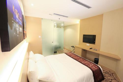 pokój hotelowy z łóżkiem i telewizorem w obiekcie Eco Tree Hotel, Melaka w Malakce