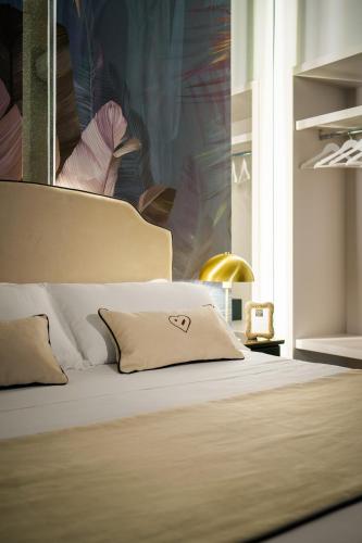 a bedroom with a bed with a pillow on it at Birkin Porto 1870 in Cagliari
