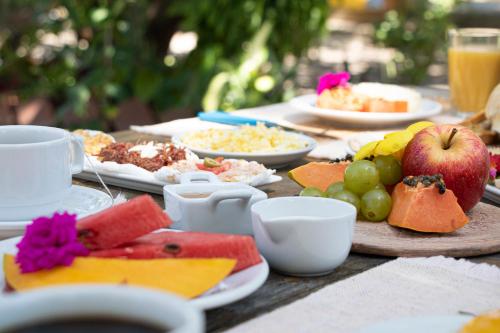 uma mesa com pratos de comida e fruta em Pousada Brisa Do Porto em Porto de Galinhas