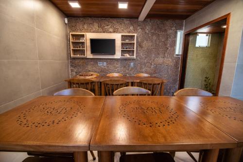 una sala da pranzo con tavolo e sedie in legno di Spazio del Sole Jurere a Florianópolis