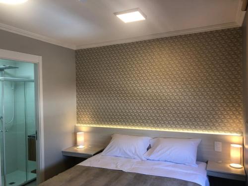 a bedroom with a bed and a wall with a brick wall at Loft aconchegante com piscina a um passo do metrô in Sao Paulo