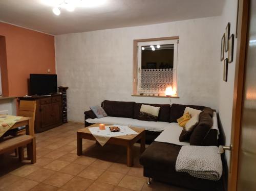 a living room with a couch and a table at Urlaub am Auberg in Gerolstein